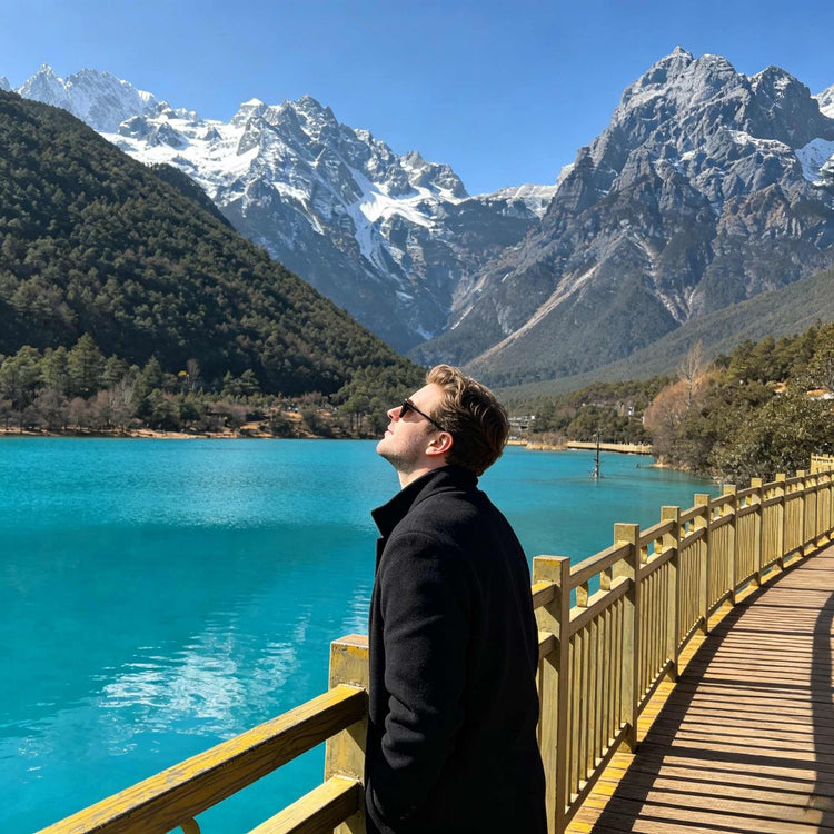 Foreign tourist enjoying the view of Jade Dragon Snow Mountain and Blue Moon Valley near Lijiang.