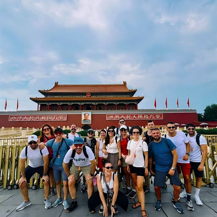 Large group of international travelers posing in front of Tiananmen Gate in Beijing on a private group China tour