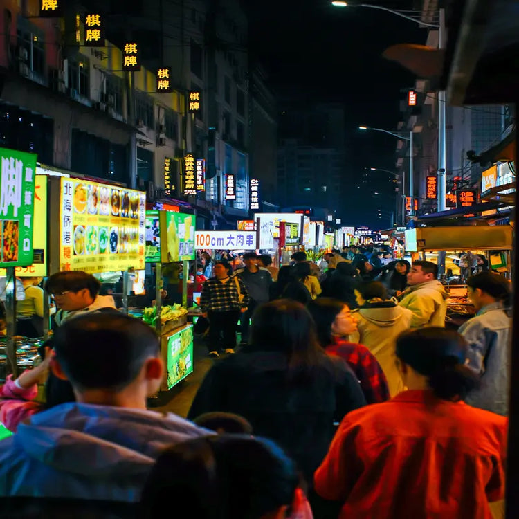 Yangshuo West Street night market with neon signs, crowds of tourists and street food stalls, Guilin Guangxi China