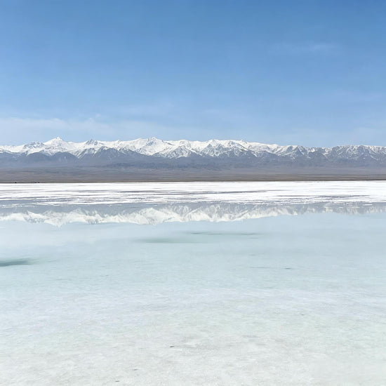 Chaka Salt Lake sky mirror scenery with calm water and snow-capped mountains