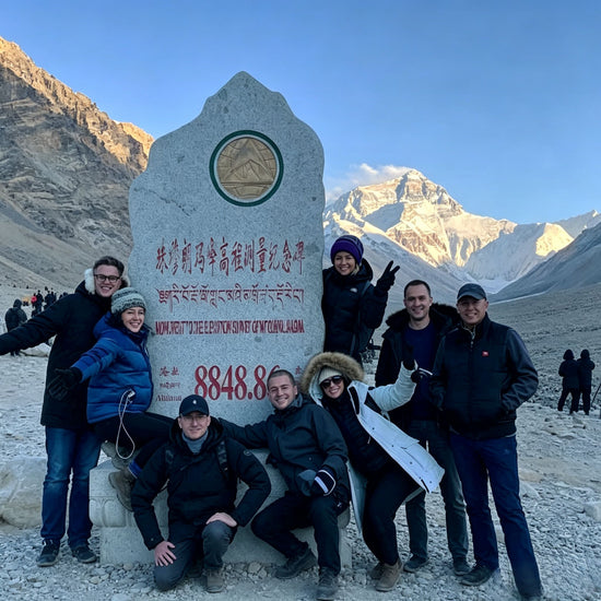 Group of foreign tourists posing at Everest Base Camp monument, Tibet