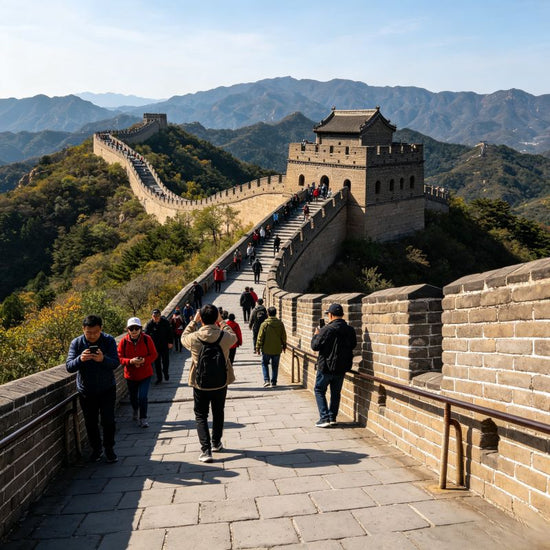 Visitors climbing the Badaling Great Wall with ancient stone fortifications winding across green mountain ranges, Beijing UNESCO World Heritage Site