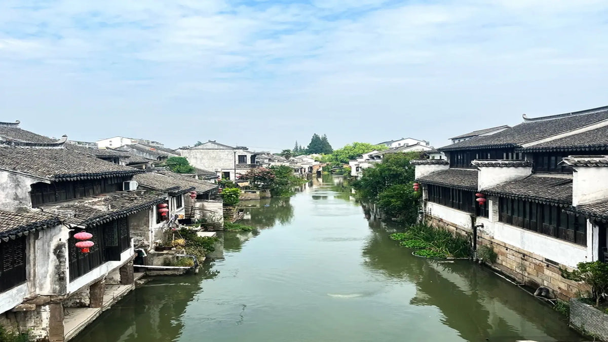Jiangnan water town canal with traditional white-walled black-tiled houses and red lanterns, Suzhou China