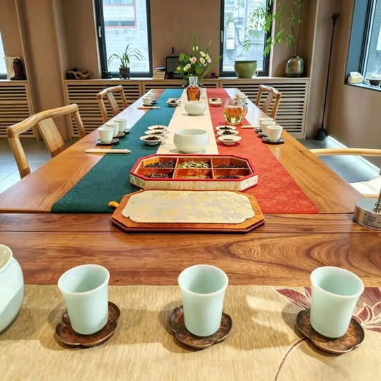 Long wooden tea table set with Ru porcelain cups and tea samples for tea tasting competition