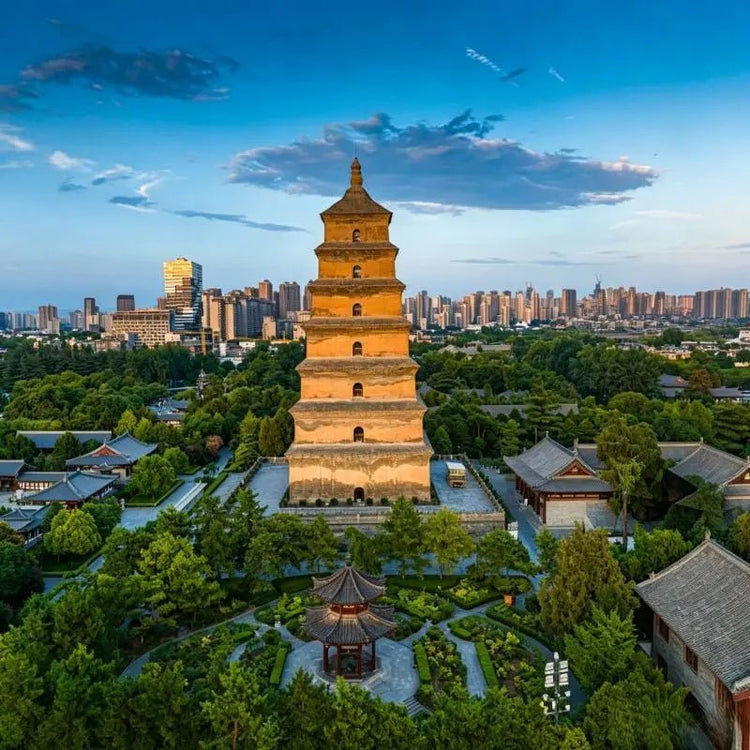 Giant Wild Goose Pagoda at Daci'en Temple in Xi'an China, ancient Tang Dynasty Buddhist pagoda with temple garden and city skyline at sunset