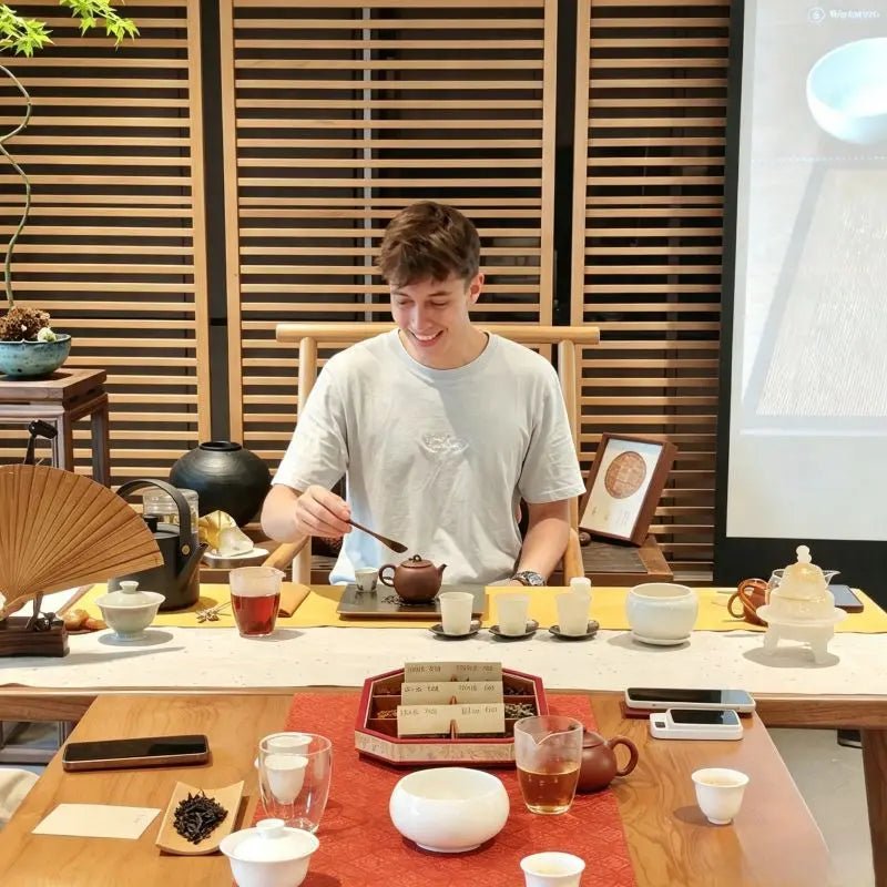 Western guest practicing Song Dynasty diancha whipped tea technique with professional guidance