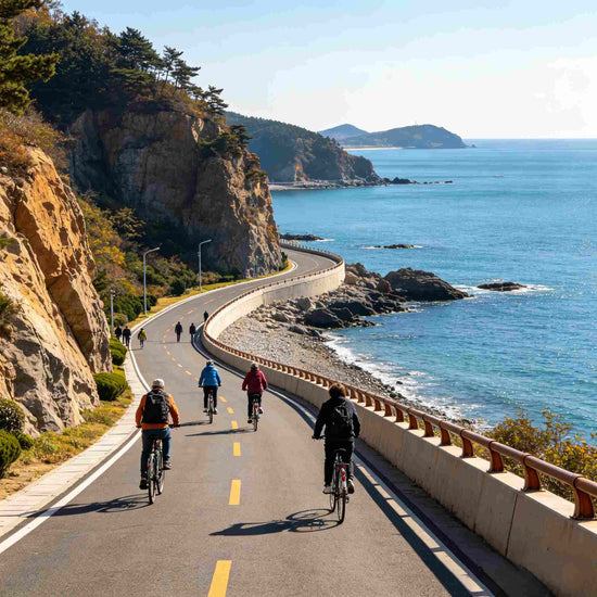 Cyclists riding along cliffside Binhai Road with blue sea view, Dalian coastal highway