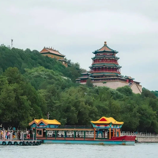 Tower of Buddhist Incense on Longevity Hill above Kunming Lake at the Summer Palace in Beijing, with traditional painted tour boat on the lake