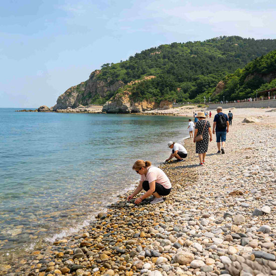 Foreign tourists relaxing on pebble beach of Bangchui Island Scenic Area, Dalian