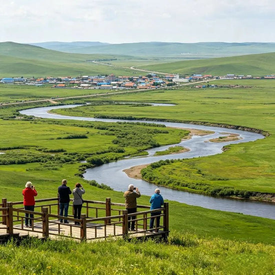 Overlook of winding river across green grassland, western tourists on viewing platform at Morigele River scenic area