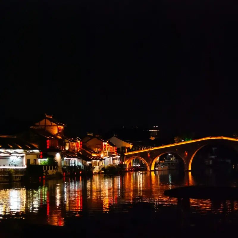 Zhujiajiao water town night stone bridge golden lights canal reflection
