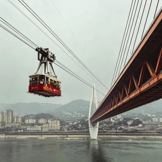 Yangtze River Cableway Chongqing, cable car crossing Yangtze River with city bridge and mountain skyline, China inbound travel attraction